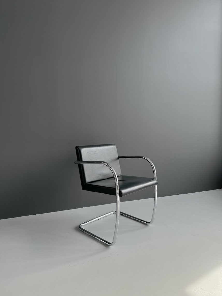 Juoda kėdė su porankiais