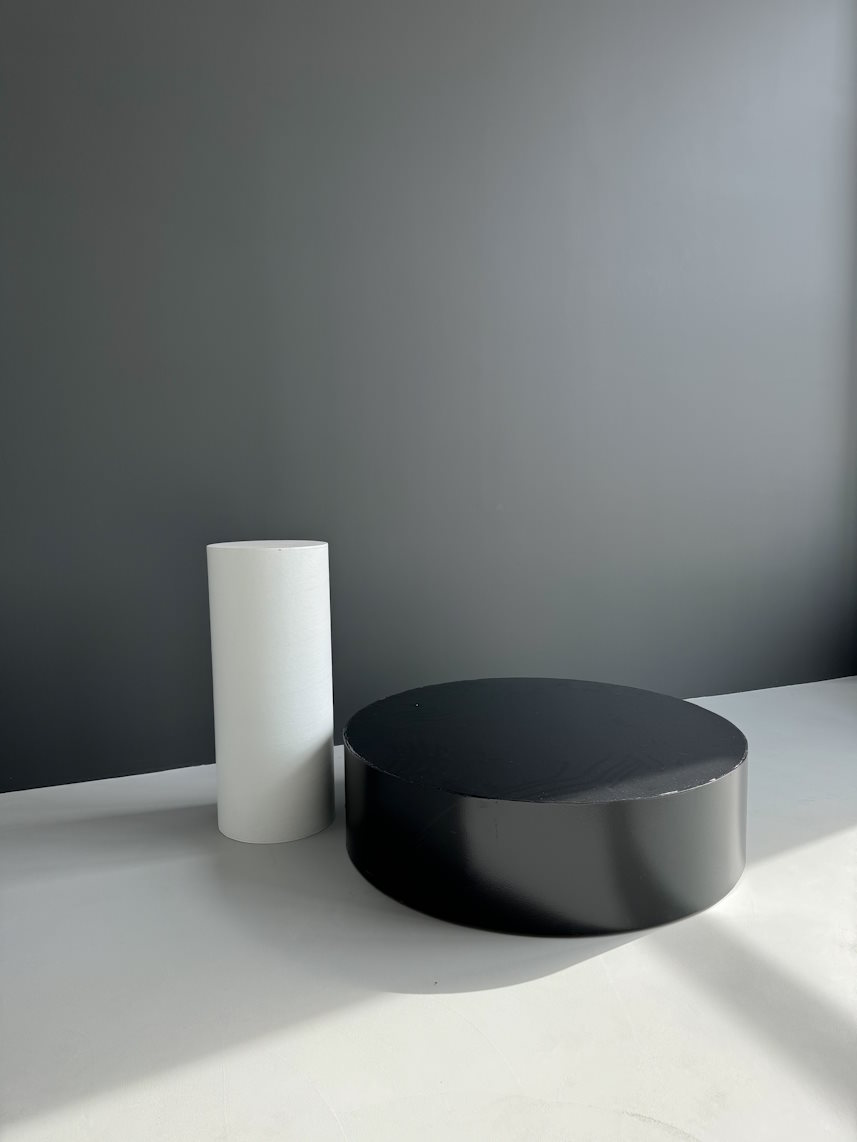 Baltas statinys ir juodas podiumas ant ratukų